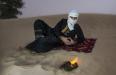 man_in_traditional_tuareg_outfit_in_a_desert_preparing_tea